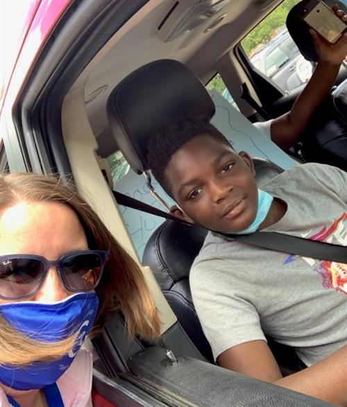 student in car with teacher at door